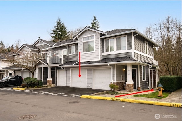 view of property featuring driveway, a garage, and a shingled roof