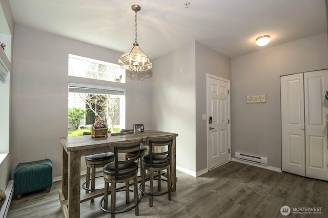 dining space with baseboard heating, dark wood-type flooring, a chandelier, baseboards, and a baseboard radiator
