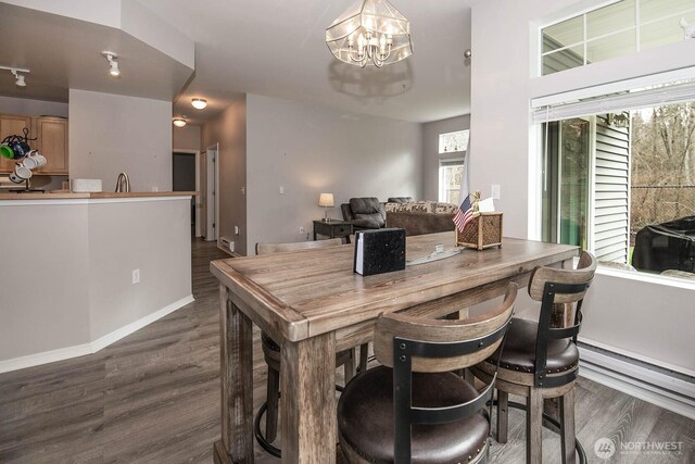 dining area with a chandelier, dark wood-style floors, and baseboards