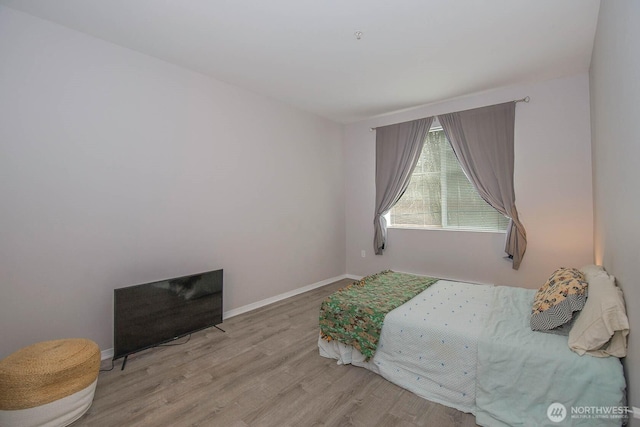 bedroom with wood finished floors and baseboards