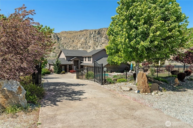 31 S Shore Dr, Orondo, WA 98843 - view of property hidden behind natural elements featuring fence, driveway, a mountain view, and stucco siding