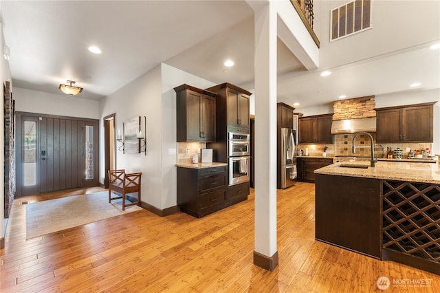 31 S Shore Dr, Orondo, WA 98843 - kitchen with stainless steel appliances, a sink, dark brown cabinetry, backsplash, and recessed lighting