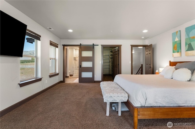 31 S Shore Dr, Orondo, WA 98843 - carpeted bedroom with a barn door, a walk in closet, recessed lighting, baseboards, and connected bathroom