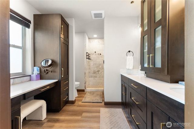 31 S Shore Dr, Orondo, WA 98843 - bathroom featuring double vanity, tiled shower, wood finished floors, toilet, and baseboards