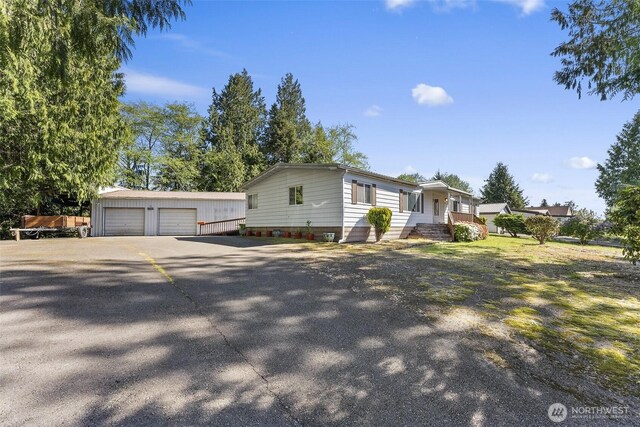 manufactured / mobile home featuring a garage and an outbuilding