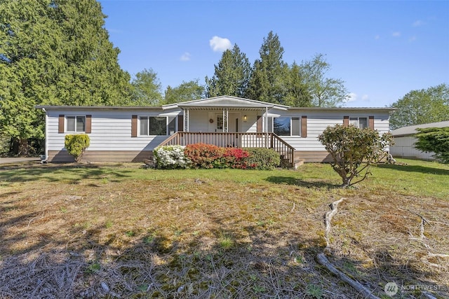 manufactured / mobile home featuring a front lawn and covered porch
