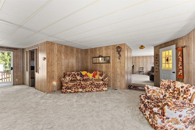carpeted living area featuring wooden walls