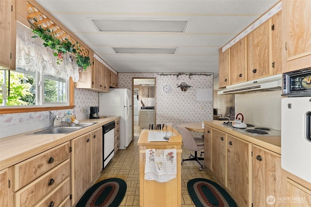kitchen featuring wallpapered walls, white appliances, a sink, under cabinet range hood, and light countertops