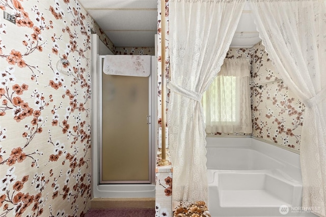 bathroom with wallpapered walls, a shower stall, and a bath