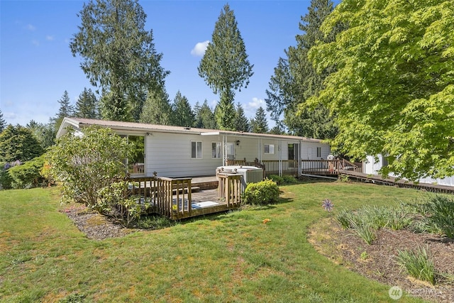 rear view of property featuring a lawn, a deck, and metal roof