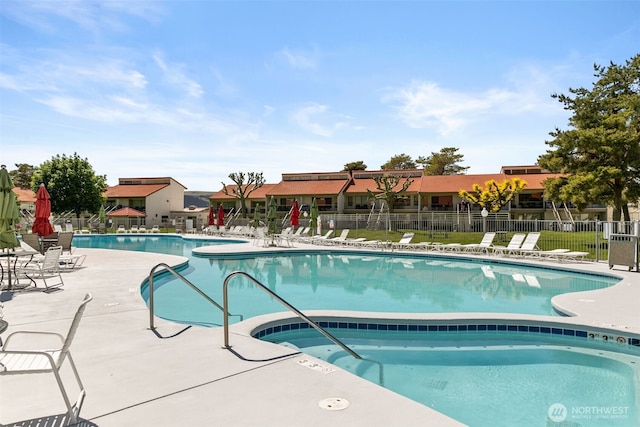 community pool featuring fence and a patio area