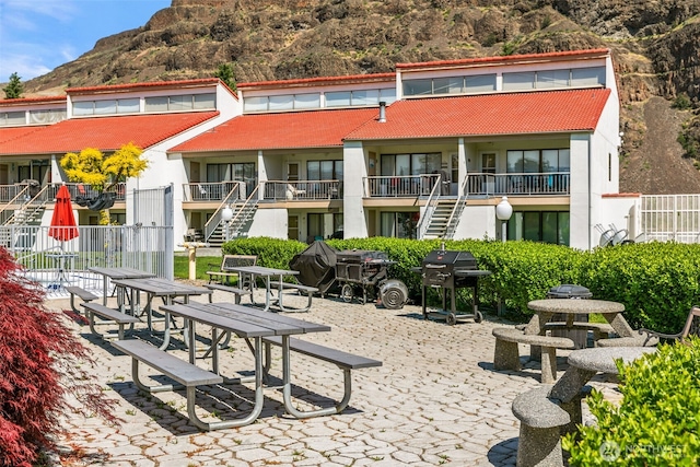 view of community with stairway, a mountain view, and a patio area