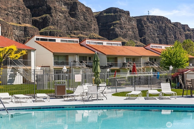 community pool featuring fence and a mountain view