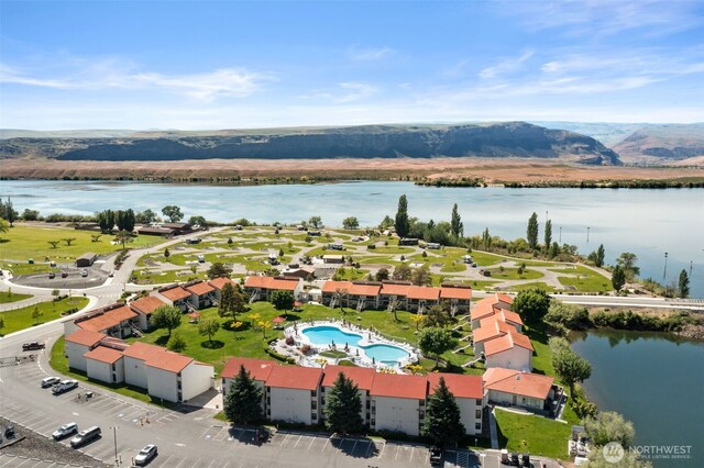 drone / aerial view of a nearby body of water and a pool