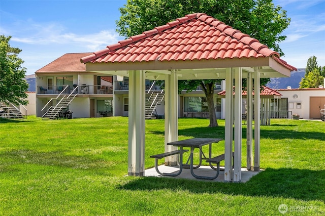 surrounding community with stairway, a lawn, and a gazebo