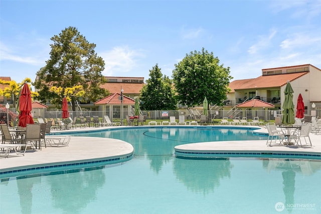 community pool featuring fence and a patio area