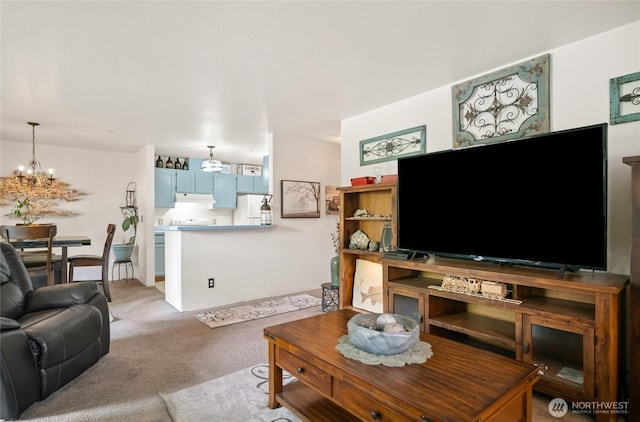 carpeted living area with a notable chandelier