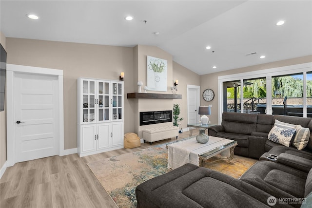 419 Edgewater Way SW, Mattawa, WA 99349 - living area with light wood-type flooring, lofted ceiling, recessed lighting, baseboards, and a glass covered fireplace