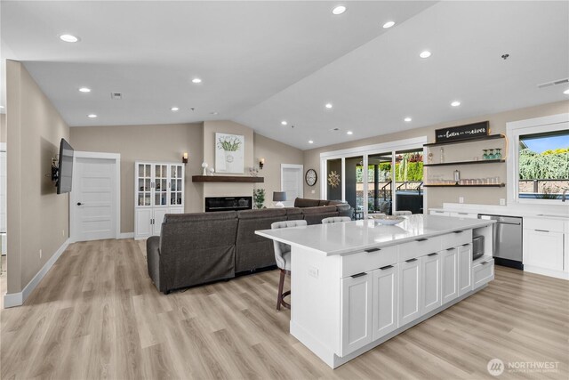 419 Edgewater Way SW, Mattawa, WA 99349 - kitchen featuring light wood-style flooring, white cabinetry, vaulted ceiling, a kitchen island, and light countertops