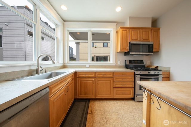 703 18th Ave S, Seattle, WA 98144 - kitchen featuring appliances with stainless steel finishes, a sink, light countertops, and recessed lighting