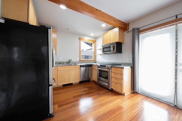 703 18th Ave S, Seattle, WA 98144 - kitchen with appliances with stainless steel finishes, a sink, light brown cabinetry, light wood-style floors, and light countertops