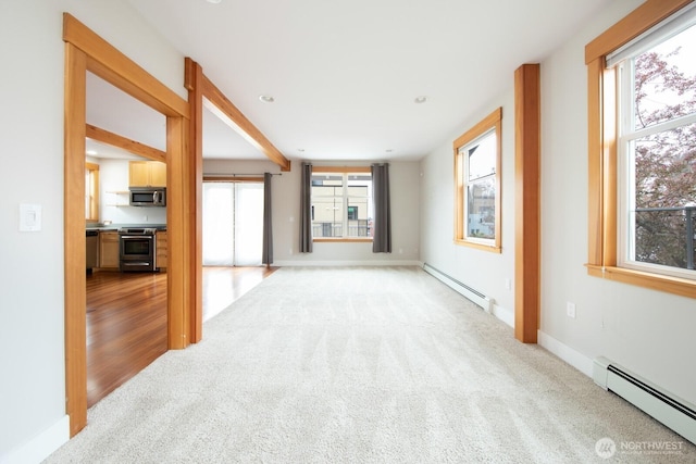 703 18th Ave S, Seattle, WA 98144 - unfurnished living room featuring a baseboard radiator, baseboard heating, light carpet, and baseboards