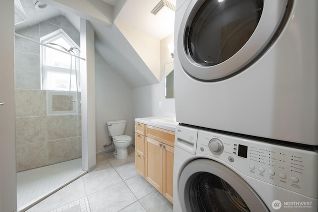 703 18th Ave S, Seattle, WA 98144 - laundry area with stacked washer / dryer and light tile patterned flooring