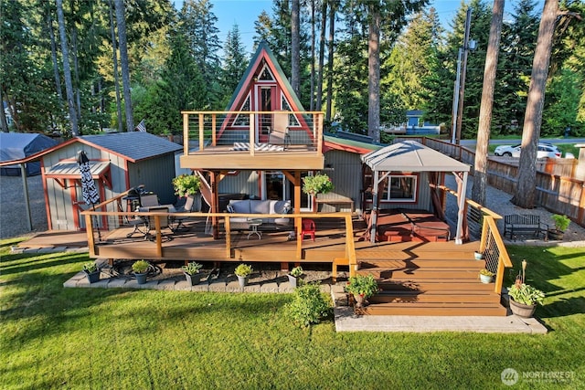rear view of house with an outdoor structure, a wooden deck, a storage shed, and view of wooded area