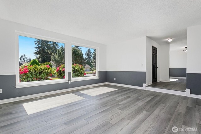 15221 42nd Ave E, Tacoma, WA 98446 - unfurnished room featuring wood finished floors, a textured ceiling, and baseboards