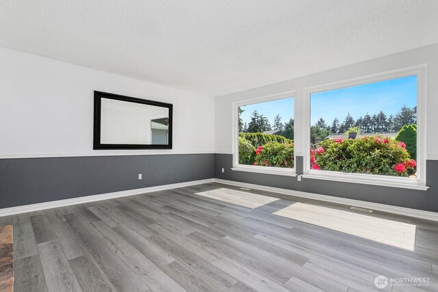 15221 42nd Ave E, Tacoma, WA 98446 - empty room featuring wood finished floors, baseboards, and a textured ceiling