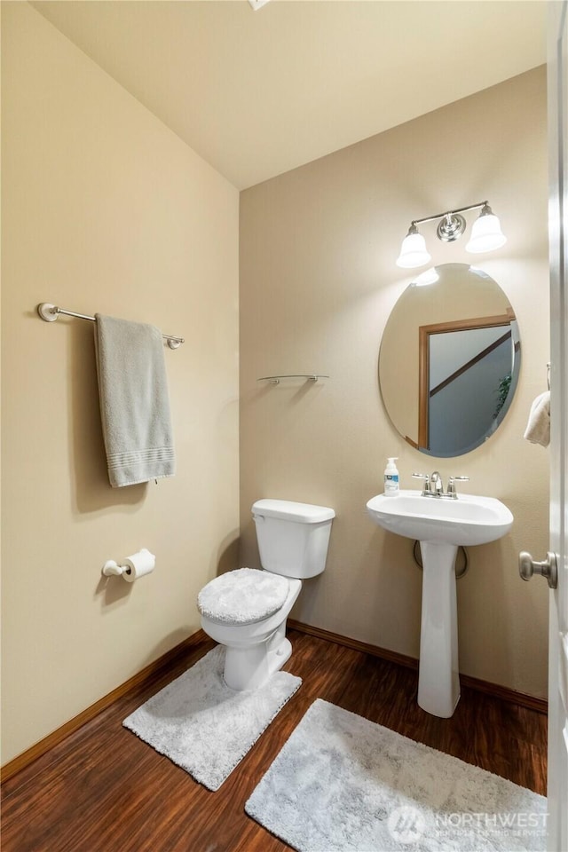 20402 98th Avenue Ct E, Graham, WA 98338 - bathroom featuring wood finished floors, toilet, baseboards, and a sink