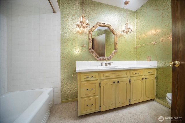 906 E 3rd Ave, Ellensburg, WA 98926 - bathroom featuring a chandelier, toilet, wallpapered walls, vanity, and washtub / shower combination