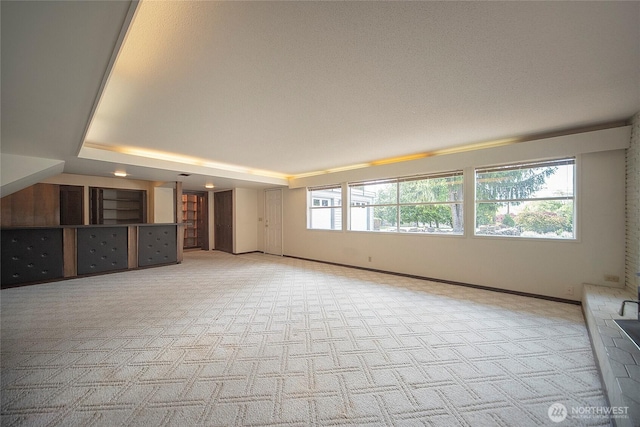 906 E 3rd Ave, Ellensburg, WA 98926 - unfurnished living room featuring carpet floors, baseboards, and a raised ceiling