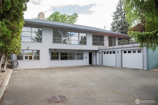 906 E 3rd Ave, Ellensburg, WA 98926 - view of front facade with driveway, a chimney, a garage, and a balcony