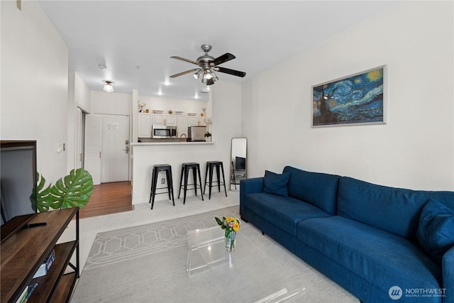 living area featuring ceiling fan and light carpet