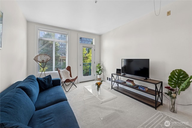 carpeted living room with baseboards