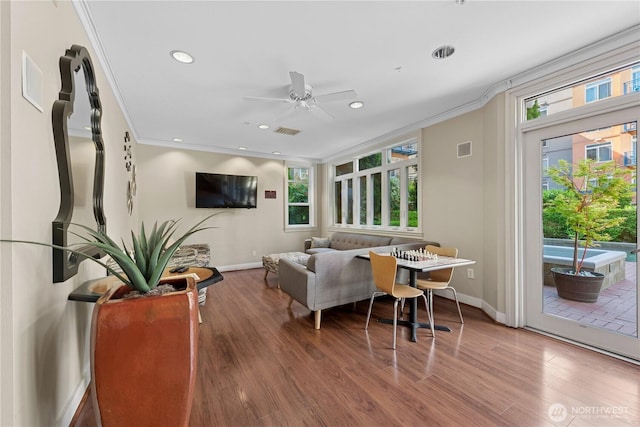 living area with ornamental molding, a ceiling fan, baseboards, wood finished floors, and recessed lighting