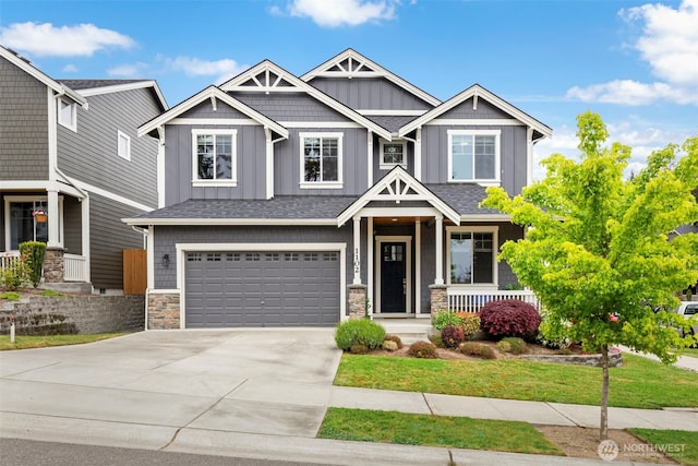 craftsman-style home with board and batten siding, a porch, concrete driveway, an attached garage, and stone siding