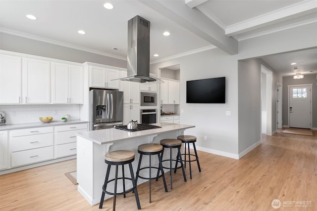 kitchen featuring stainless steel appliances, island exhaust hood, tasteful backsplash, white cabinetry, and ornamental molding