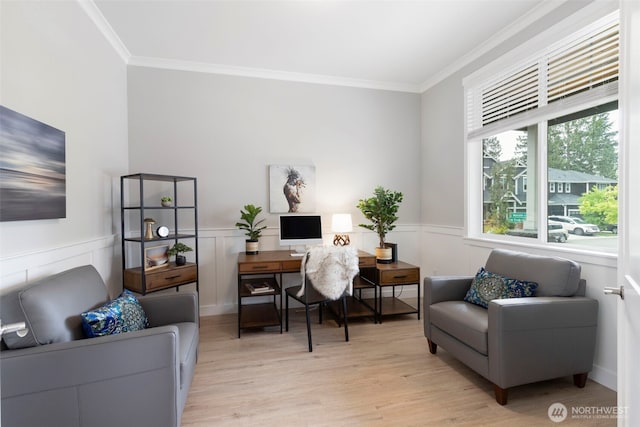 office space featuring crown molding, light wood-type flooring, and wainscoting