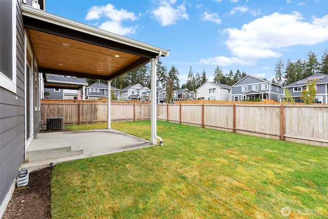 view of yard featuring a residential view, central air condition unit, and a patio area