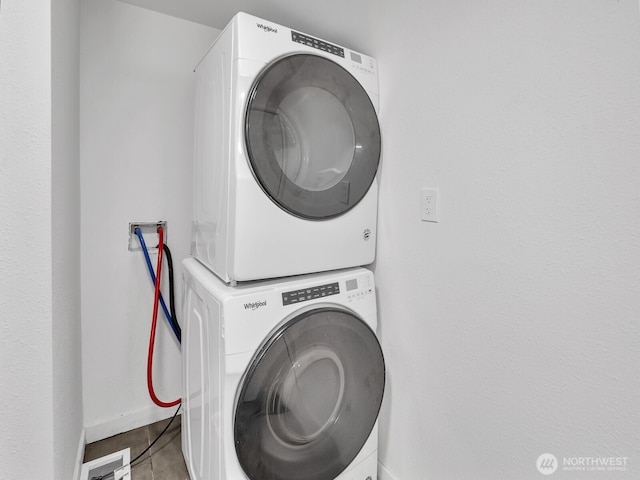 clothes washing area featuring laundry area, stacked washer / drying machine, baseboards, and visible vents