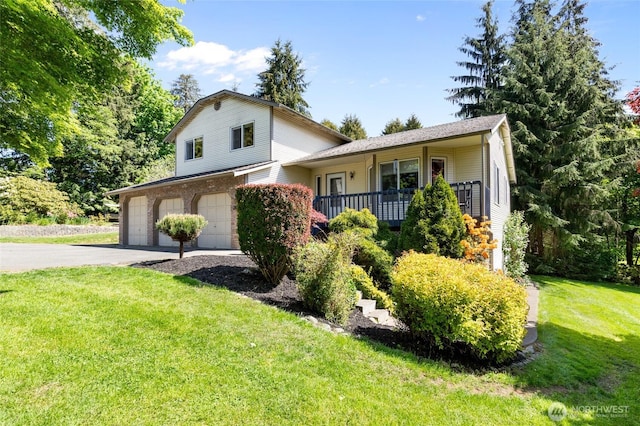 split level home featuring a garage, driveway, and a front lawn