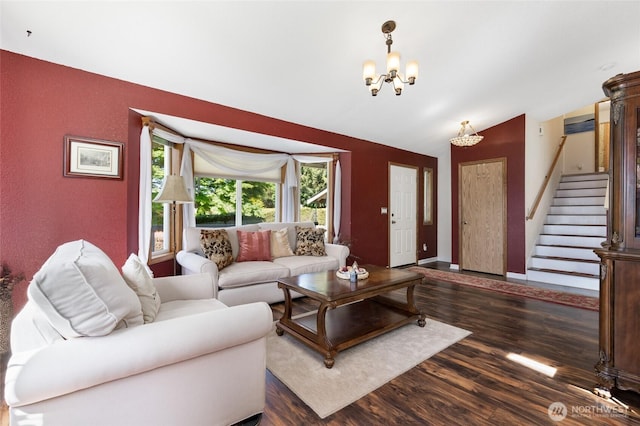 living area featuring vaulted ceiling, stairs, wood finished floors, a chandelier, and baseboards