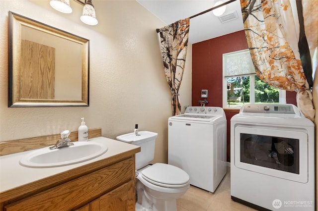 bathroom with separate washer and dryer, tile patterned flooring, toilet, and vanity