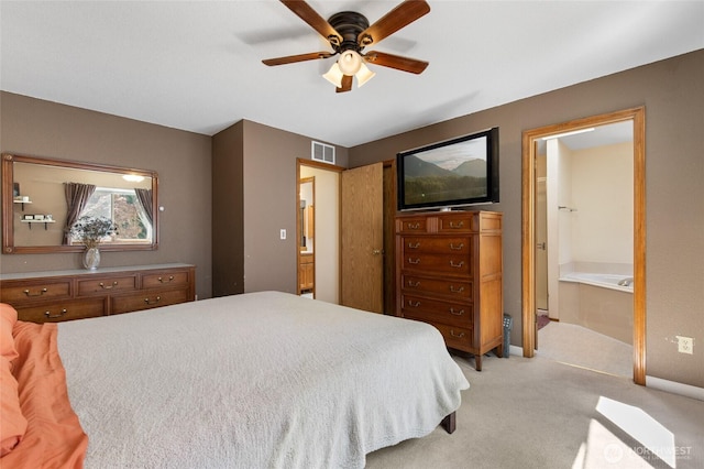 bedroom with light colored carpet, ensuite bathroom, and ceiling fan