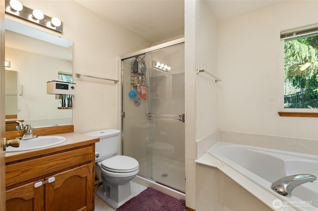 full bath with vanity, a bath, a stall shower, and toilet