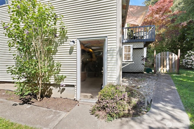 property entrance with a balcony and fence
