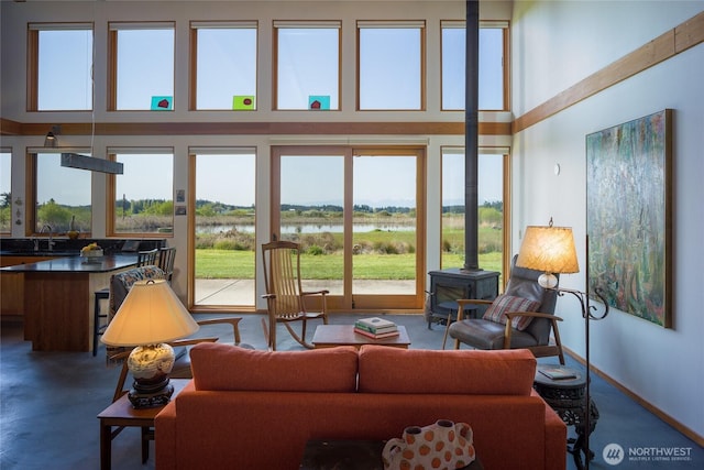 5621 Fisherman Bay Rd, Lopez Island, WA 98261 - living room featuring a towering ceiling, a wood stove, a water view, and healthy amount of natural light