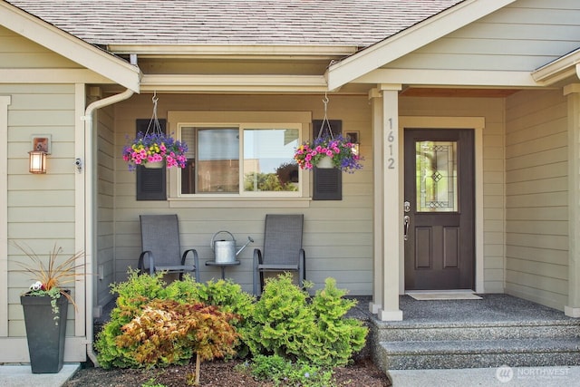 view of exterior entry with a shingled roof